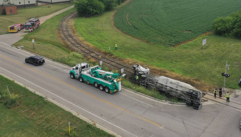 Wallace firefighters work the scene of an overturned sand hauler at the intersection of North 15th Road and U.S. Route 6 on Wednesday, July 9, 2025 in Ottawa. The semi overturned on the train tracks. La Salle County Sheriff and Ottawa Police assisted with the crash.
