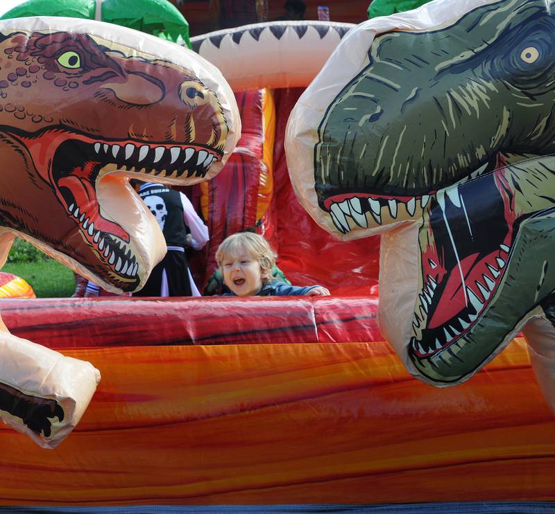 This youngster seems a bit frightened of the two inflatable T- Rex attached to a bounce house on the Jordan Block in Ottawa during the Halloween celebration Saturday.