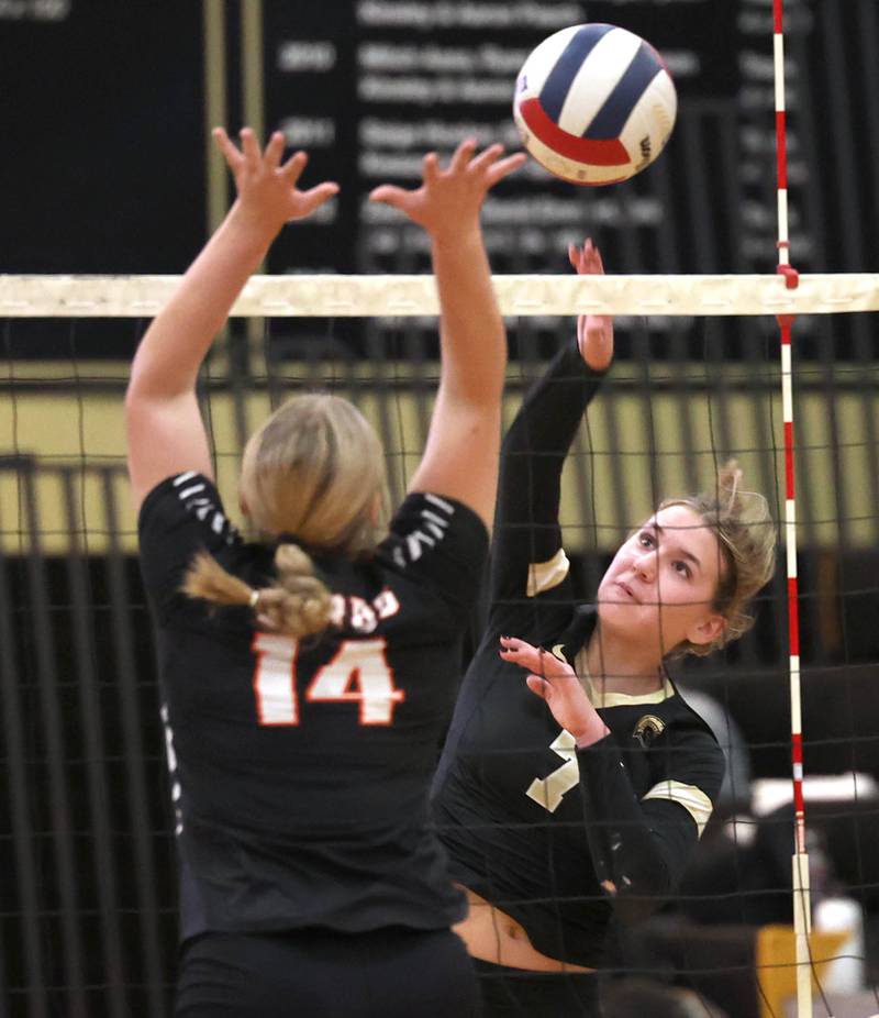 Sycamore's Laci Neece spikes the ball by DeKalb’s Brooklynn Siebrasse during their match Monday, Oct. 16, 2023, at Sycamore High School.
