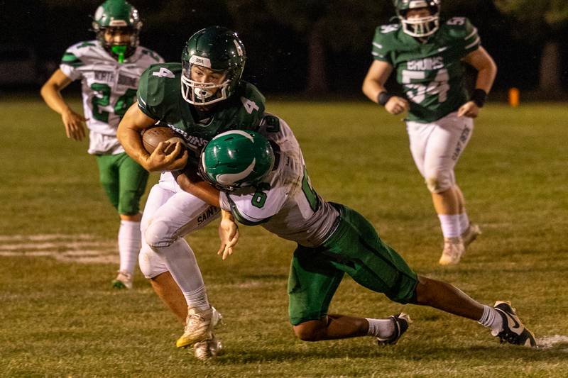 AJ Hermes (4) of St. Bede runs ball as Leo Ovalle (6) of North Boone tackles him on Friday, Sept 12, 2025 at Captain Thomas J. Heitmann field in Peru.
