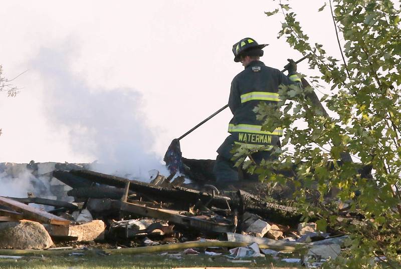 A firefighter picks through the rubble of a house Tuesday, Oct. 17, 2023, after an explosion at the residence on Goble Road in Earlville. Several fire departments responded to the incident at the single-family home that left one person hospitalized.