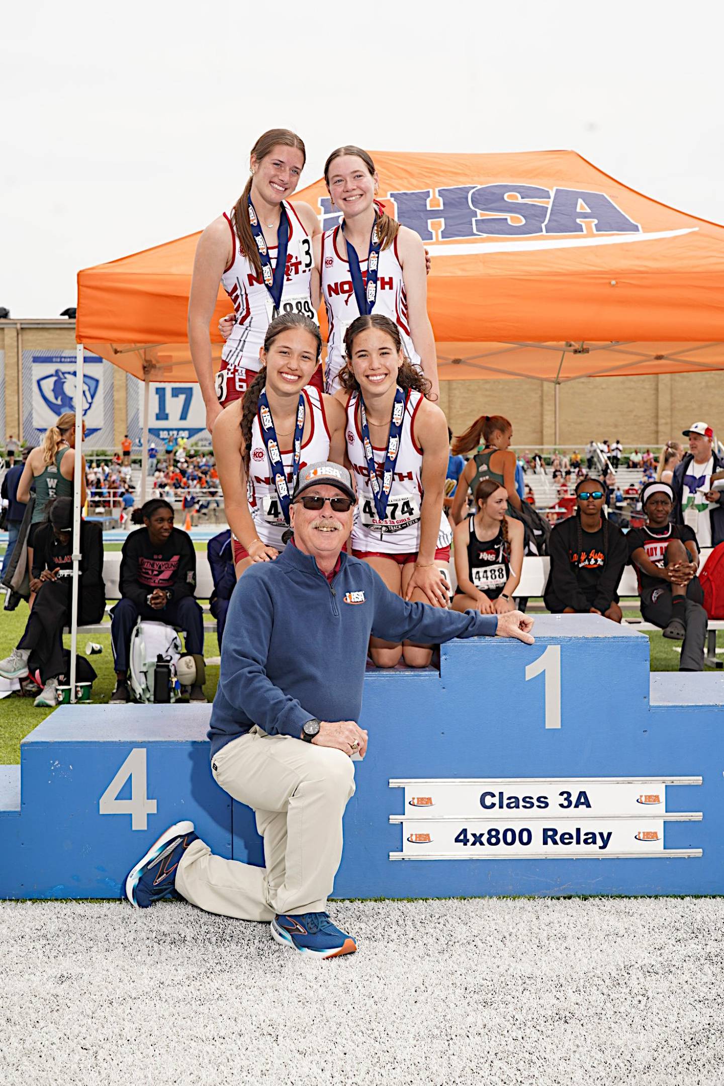 Plainfield North athletic director Ron Lear (bottom) poses with the Tigers' 4x800-meter relay team, which took second in the Class 3A state meet.