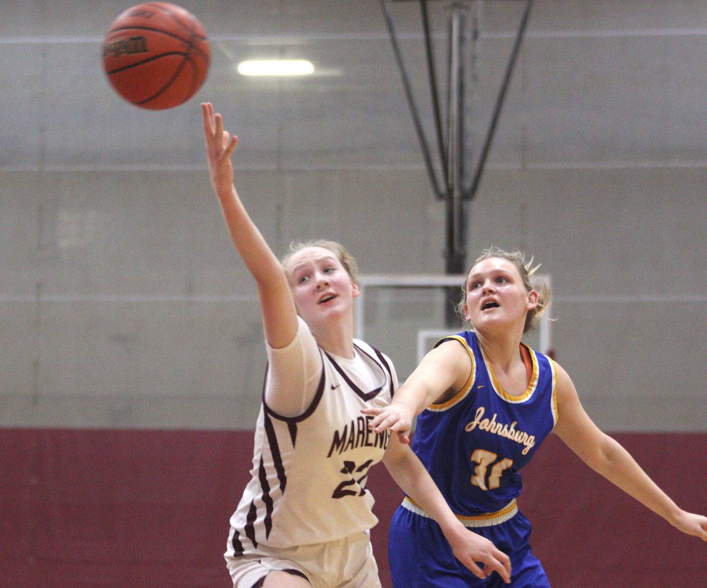Marengo’s Dayna Carr, left, and Johnsburg’s Sophie Person look for the ball in varsity girls basketball at Marengo Tuesday night.