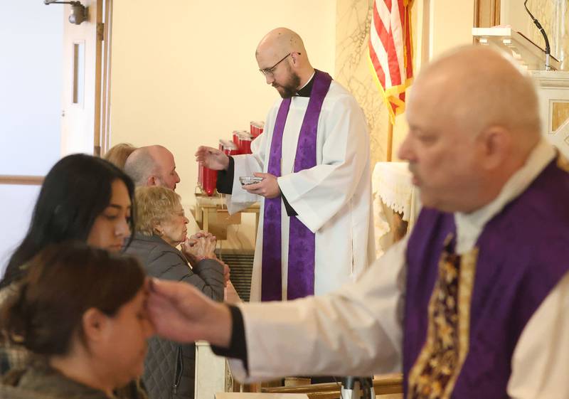 Rev. Tom Otto and Rev. Jeffery Small distribute ashes during Ash Wednesday Mass on Wednesday, Feb. 18, 2026 atThe Queen of the Holy Rosary Memorial Shrine in La Salle. Ash Wednesday marks the beginning of Lent eading up to observances of Jesus' death on Good Friday and resurrection on Easter.