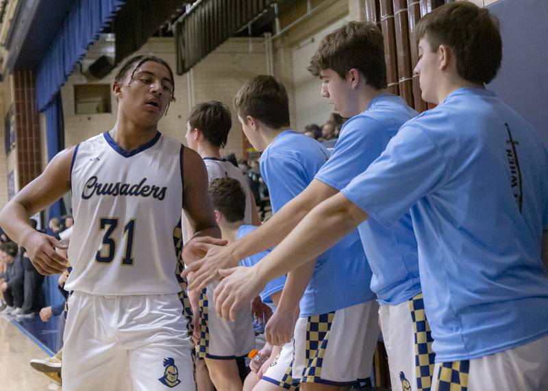 Marcus Baker is congratulated by the bench for his performance in the first half during the game on January 10, 2025 at Marquette Academy.