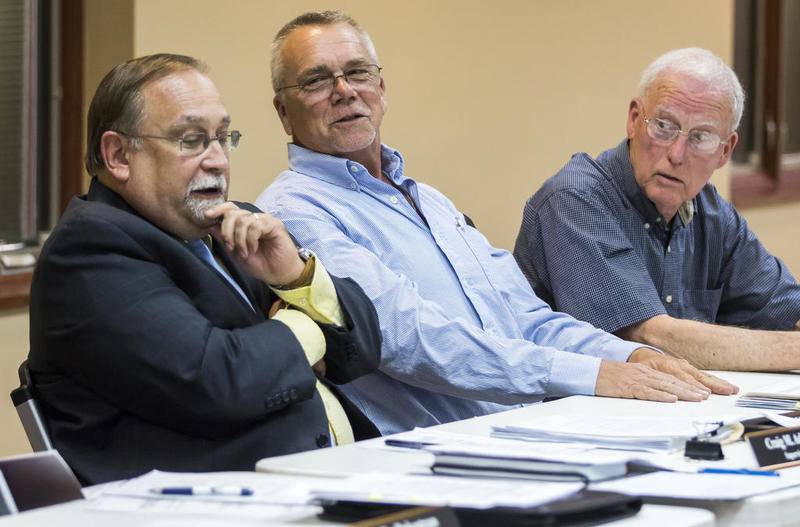 Township Supervisor Craig Adams (left) and newly elected Trustees Bill Cunningham and Bob Anderson discuss matters Thursday during the first McHenry Township meeting since the April election.