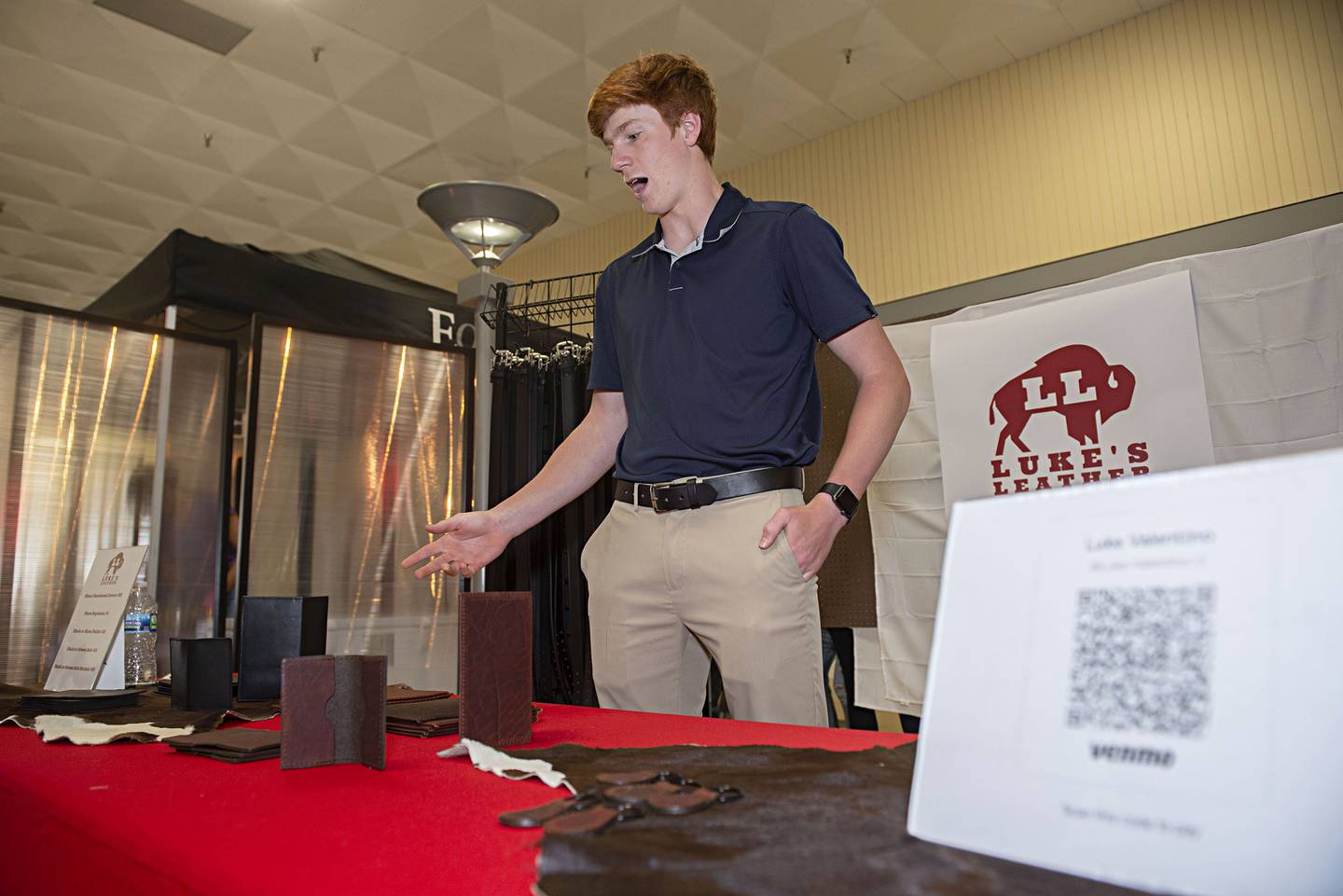 Sterling High School senior Luke Valentino displays his cow and bison hide goods Thursday, April 28, 2022 at his Luke’s Leather booth. Valentino offers up checkbook covers, belts, keyring and card holders.