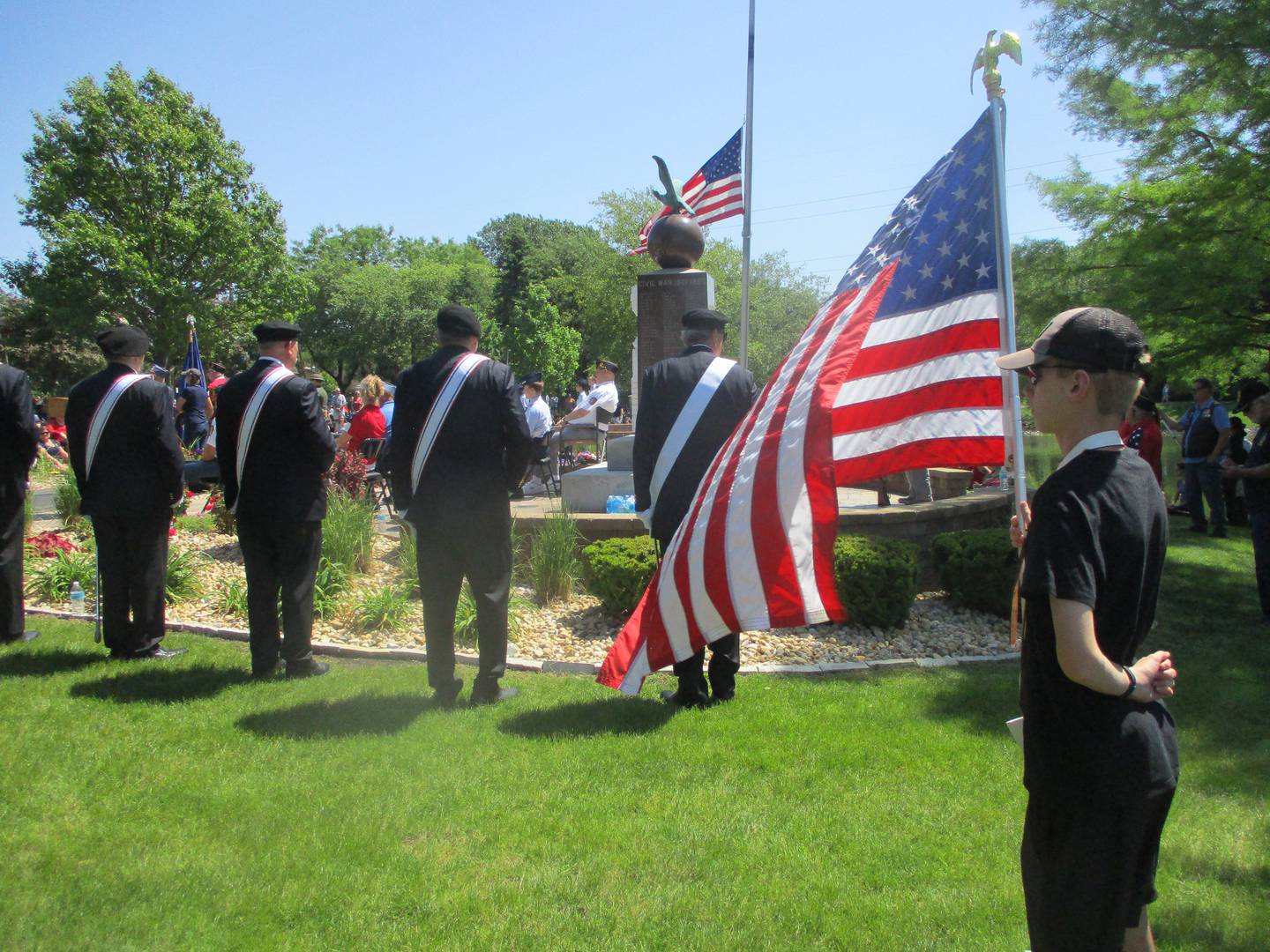 aden DeGraaf, a member of the Plainfield Central High School marching band, holds the flag during a Memorial Day ceremony at Settlers' Park in Plainfield on Monday. May 25, 2026