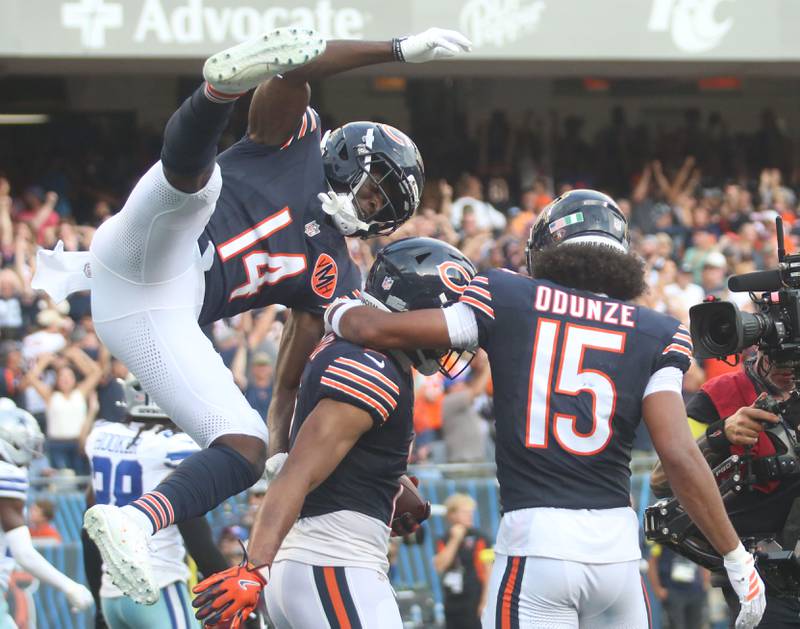 Chicago Bears players (from left) wide receiver Olamide Zaccheaus, wide receiver DJ Moore, and wide receiver Rome Odunze react after scoring a touchdown against the Dallas Cowboys on Sunday, Sept. 21, 2025 at Soldier Field.