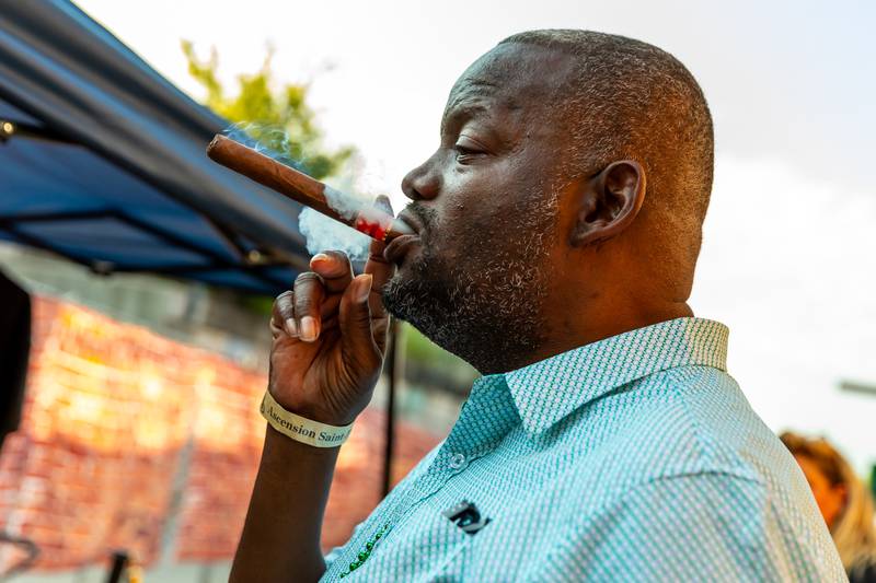 Elwood resident Michael Norton enjoys a cigar from Joliet establishment Rolling Smokes in the Hookah Alley area of New Orleans North Festival on Aug. 16, 2024.