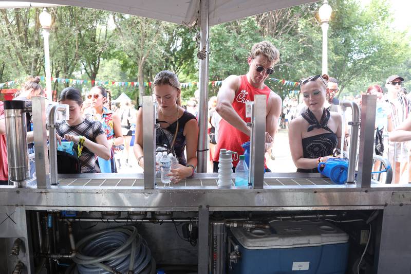 A group of festival goers fill up their water bottles at the Hydration Station at Lollapalooza on Saturday, Aug. 3, 2024 in Chicago.