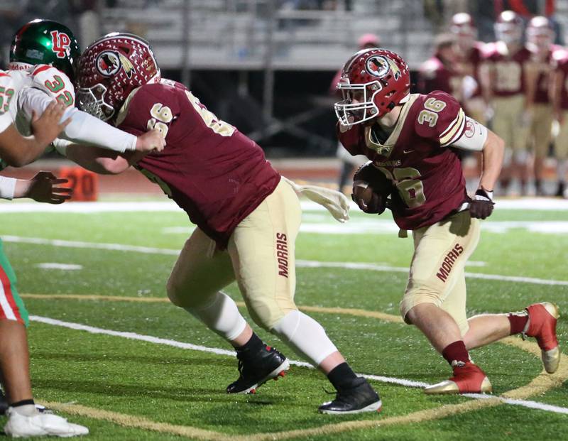 Morris's Jacob Swartz (36) runs the ball as teammate Nick Perry (66) blocks L-P's Connor Lorden (32) during the Class 5A round one football game on Friday, Oct. 28, 2022 in Morris.