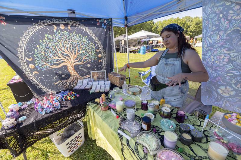 Katy Beckingham of Dixon talks about her candles Friday, July 12, 2024 at a booth at Herbal Roots’ Cannafest. Beckingham is partners with her sister and a friend to supply the booth with unique items.