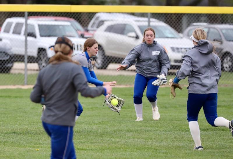 Princeton center fielder Caroline Keutzer fields the ball surrounded by teammates Tuesday at Mendota.