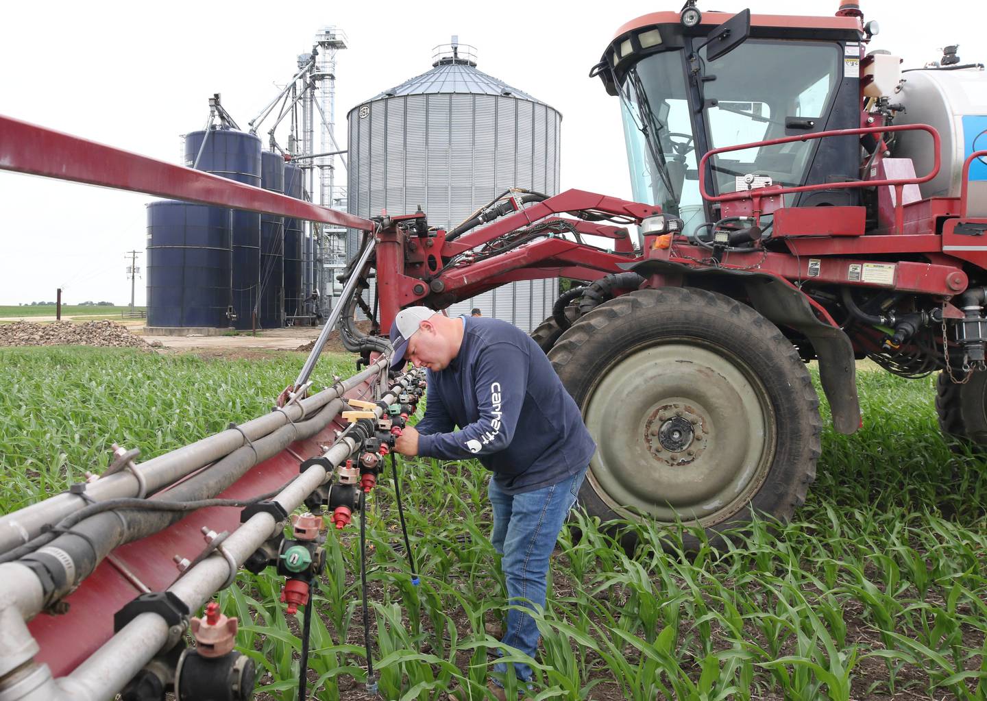 Farmer Mike Schweitzer changes the nozzles on the sprayer tractor in one of his fields Friday, June 16, 2023, on his farm in Malta.
