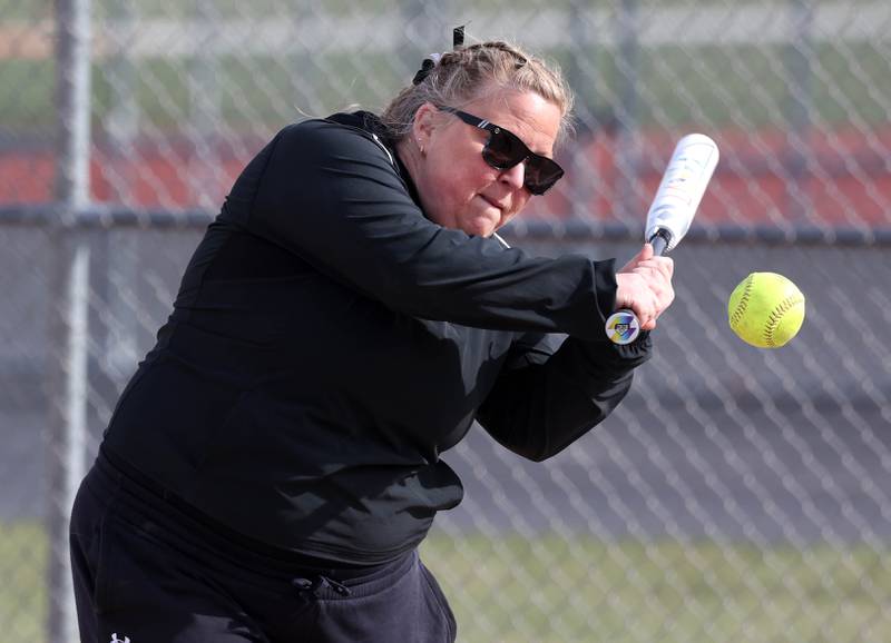 New DeKalb softball head coach Erica Swan hits ball during infield warmups Wednesday, April 16, 2025, before their game against Naperville Central at DeKalb High School.