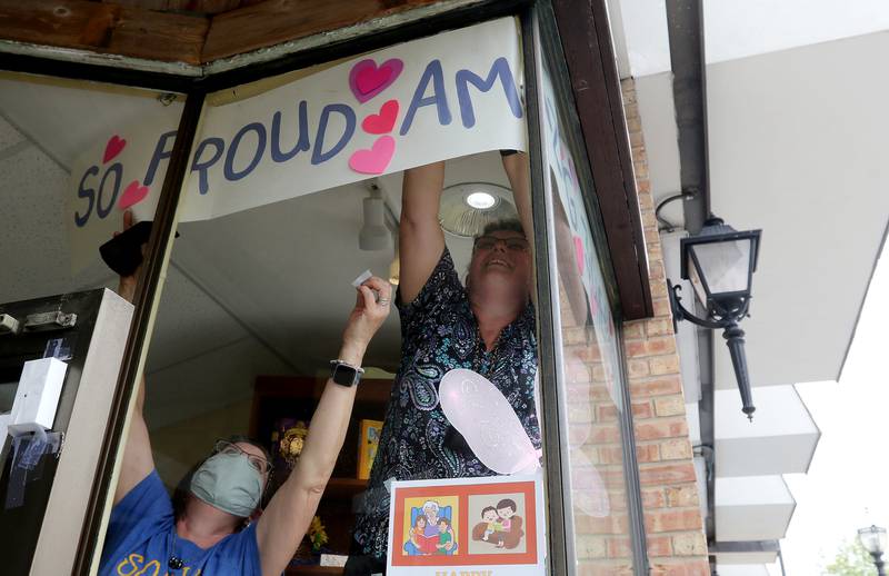Sue Jensen, left, and Pam Johnson decorate Green Read Bookstore owned by Environmental Defenders of McHenry County as they prepare for a parade through downtown for Grace Kinstler, a Crystal Lake Central High School graduate and finalist on "American Idol," on Tuesday, May 18, 2021, in Crystal Lake.