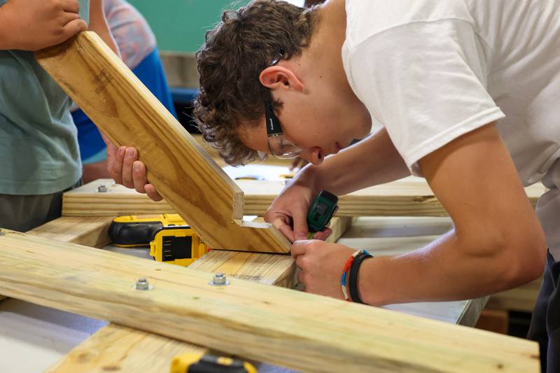 Alex Vincic, 14, of Lake Villa, carefully measures for the picnic table support beam placement during Tool Time at Camp Shaw-Waw-Nas-See on Wednesday, July 16, 2025.
