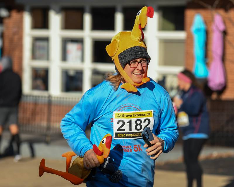 Amy Vogt of Downers Grove, wears a turkey hat while running in the Grove Express 5k race on Thursday Nov. 23, 2023, held in downtown Downers Grove.