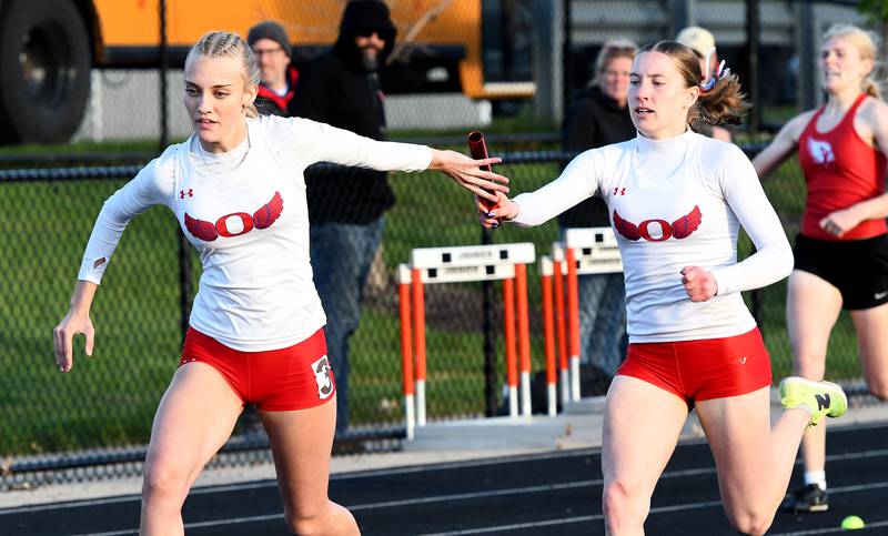 Oregon's  Jillian Hammer hands the baton to Skylar Bishop in the final exchange of the 4x200 relay at the 1A Winnebago Sectional on Wednesday, May 13, 2026. Oregon placed second in the event to advance to the state meet.