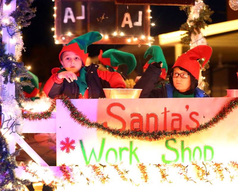 Children ride the "Santa's Work Shop" float in the Peru Hometown Christmas parade on Saturday Dec. 4, 2021 in Peru.