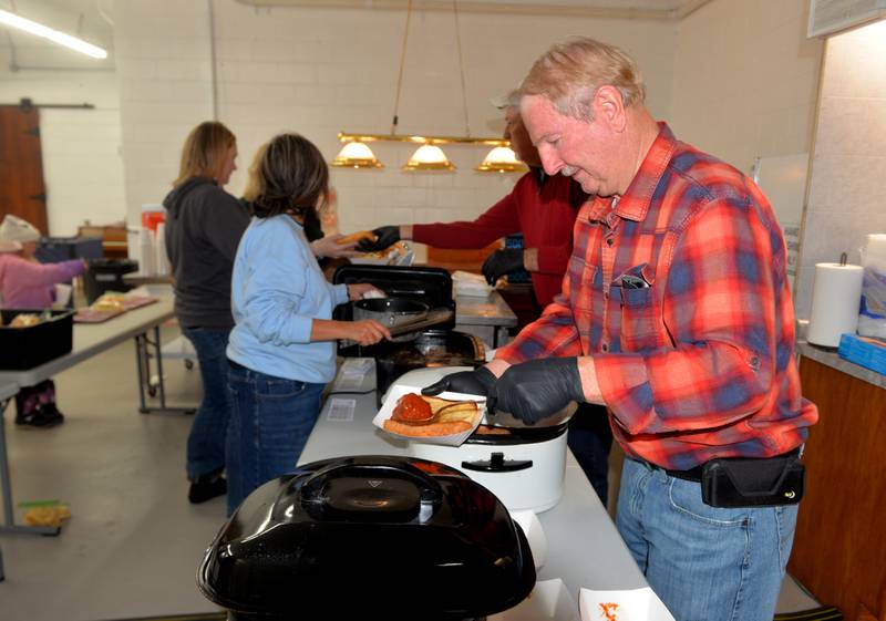 Gary Ludwig serves up a meatball sandwich during Forreston's Christmas in the Country on Friday, Dec. 1, 2023. The meal, offered by the Sauerkraut Days committee. was one of the activities held on a snowy night in downtown Forreston.