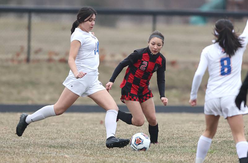 Genoa-Kingston's Yuliza Fuentes (left) kicks the ball away from Indian Creek's Sally Diaz during their game Thursday, March 16, 2023, at the Pack Park Sports Complex in Waterman.