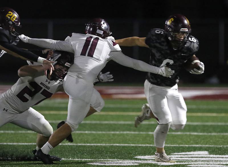 Richmond-Burton's Hunter Carley runs away from Marengo's Brody Carney a Kishwaukee River Conference football game on Friday, Oct. 17, 2025, at Richmond-Burton High School in Richmond.