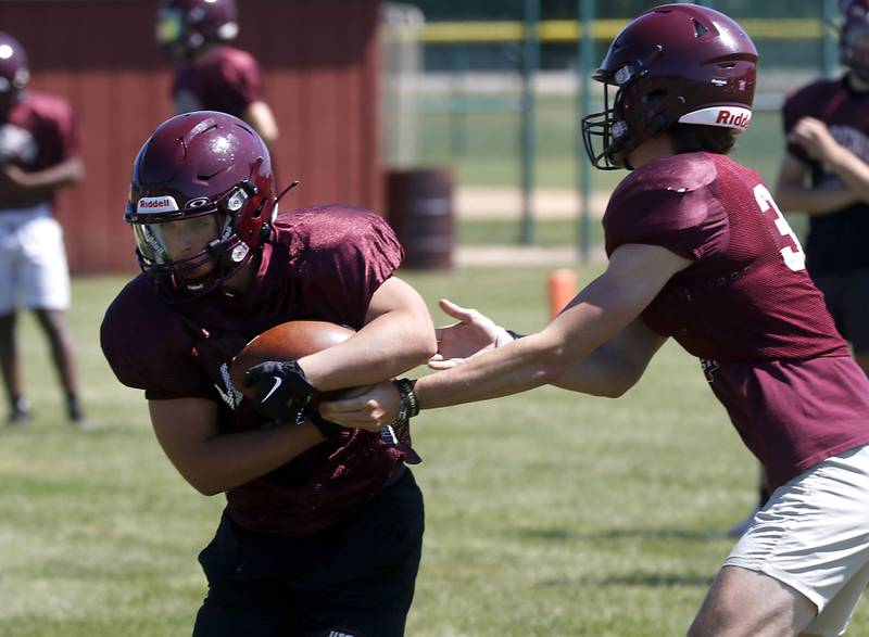 Marengo’s Joseph Leibrandt receives a hand off from quarterback Josh Holst during summer football practice Monday, June 27, 2022, at Marengo Community High School in Marengo.