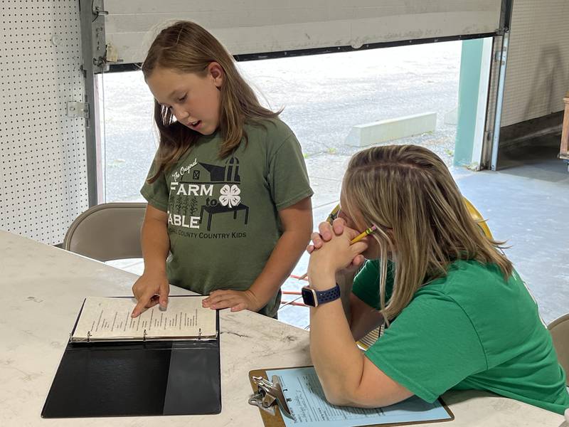 Kendall County Country Kids 4-H club’s Adelynn Landers of Mendota shares her theatre arts project
with a 4-H judge.