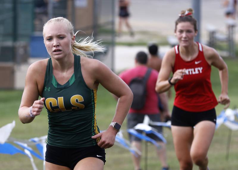 Crystal Lake South’s Abby Machesky runs to the finish line in front of Huntley’s Ava Allison during the girls race of the McHenry County Cross Country Meet Saturday, August 27, 2022, at Emricson Park in Woodstock.