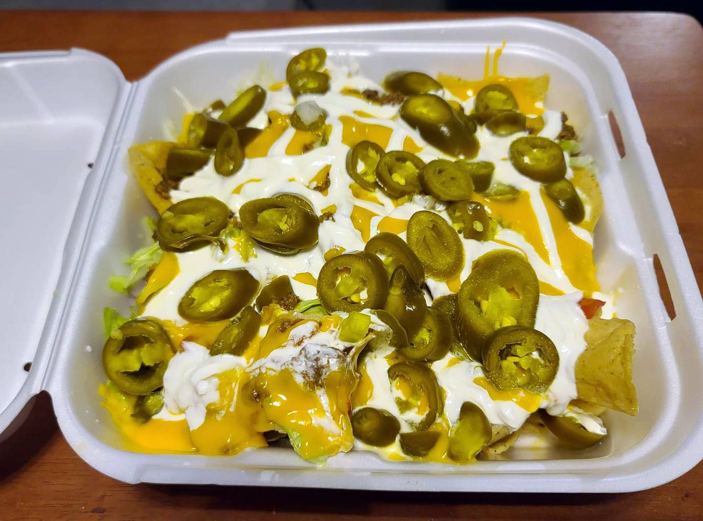 Ziggy's Bar & Grill in Marseille offers both dine-in and take-out.  This loaded nacho to-go appetizer — which includes ground beef, cheese sauce, onion, lettuce, tomato, and the optional addition of jalapenos — is large enough to serve as an entrée.
