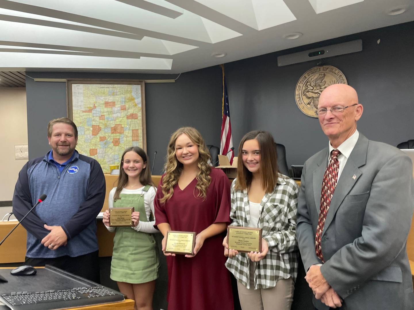 Chris Dvorak (left), regional superintendent of schools for La Salle County Board, and Don Jensen (right), chairman of the La Salle County Board, present the county's monthly student awards to (second from left) Ellie Nimke of Northlawn Junior High School, and Jenna Gamons and Dixie Smick, both of Marquette Academy.