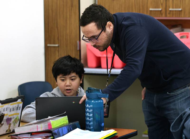 Caio Gomes, a seventh grade teacher from Brazil, helps student Kevin Nguyen Monday, Feb. 2, 2026, during his class at Clinton Rosette Middle School in DeKalb.