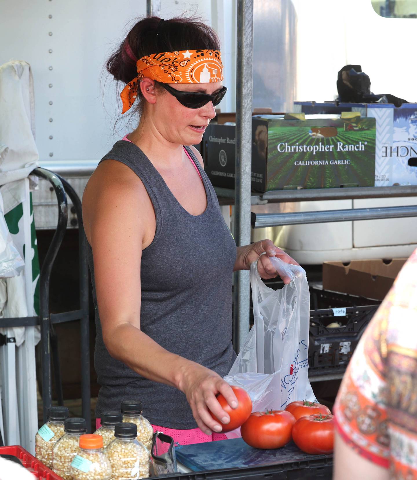 Katie Harmata at the Theis Farm Market booth bags up some tomatoes for a customer during opening day for the DeKalb Farmers Market Thursday, June 1, 2023, at Van Buer Plaza in downtown DeKalb. The Farmers Market is open every Thursday from 10 am to 2 pm through September 21.
