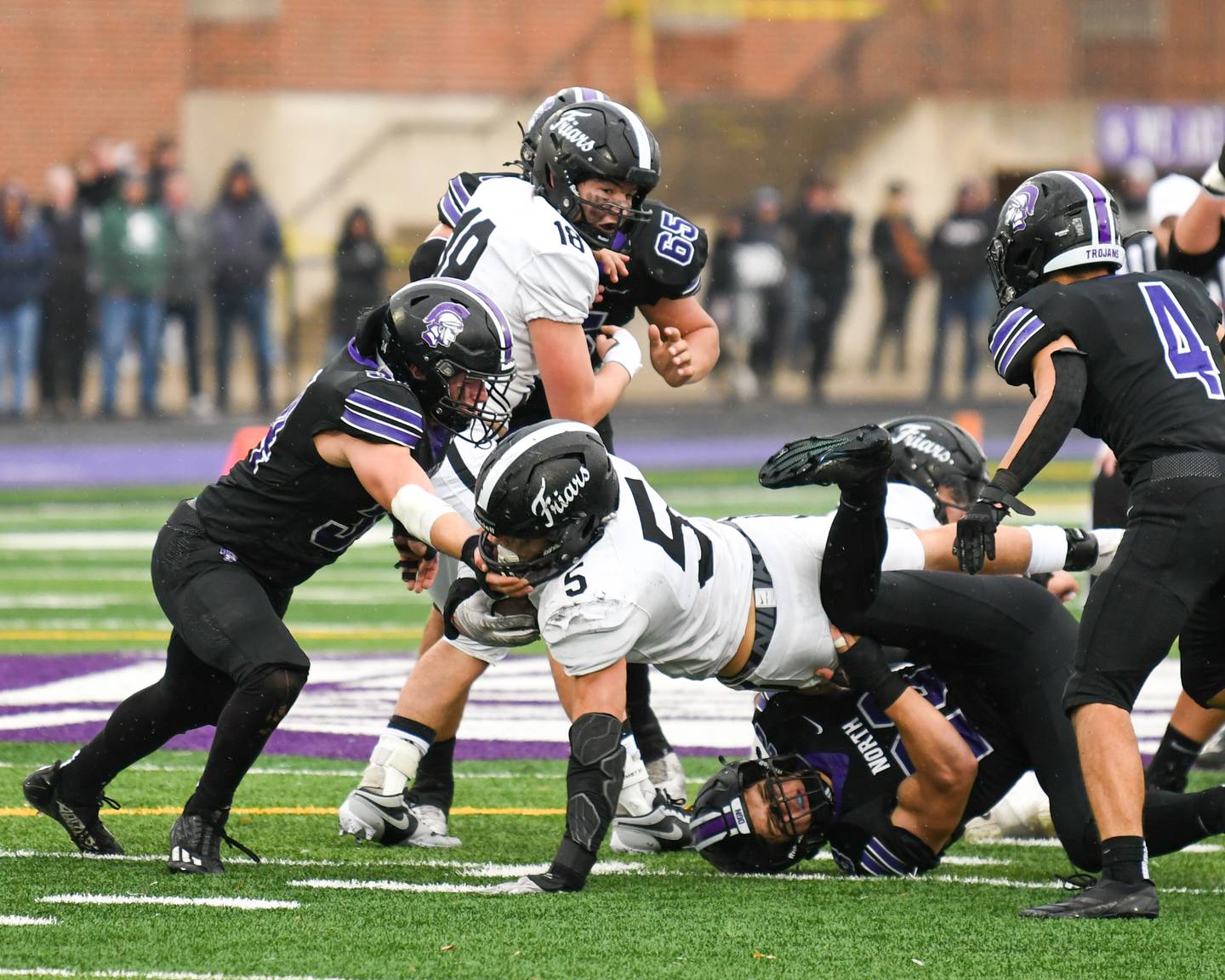 Fenwick's Jack Paris (5) gains some extra yards as he stretches out while being brought down by Downers Grove North's Joe LaSota (23) on Saturday Nov. 9, 2024, during the second week of the class 7A game held at Downers Grove North High School.
