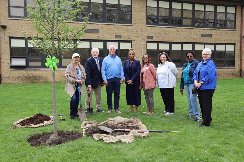 Joliet City Councilwoman Jan Hallums Quillman, Joliet City Councilman Pat Mudron, Mayor of Joliet Terry D’Arcy, Edna Keith Elementary School Principal Laticha Walton, Joliet Public Schools District 86 Deputy Superintendent Dr. Tanisha Cannon, Joliet Public Schools District 86 Assistant Superintendent Dr. Judie Nash, City of Joliet Tree Advisory Board Member Betsy Satcher, and Tree Advisory Board Chairperson Rita Renwick pose by the new Summer Elixir Elm tree at Edna Keith Elementary School on April 10, 2025.