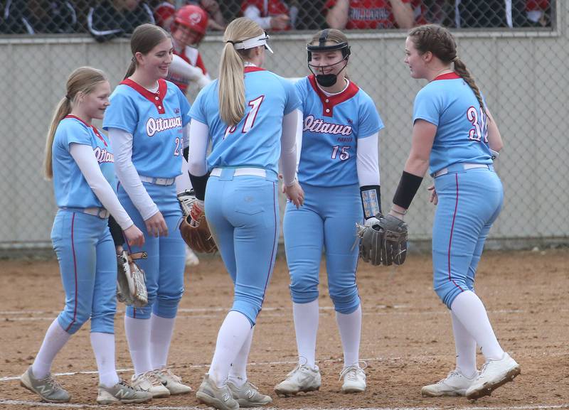 Ottawa softball players Rylee Harsted, Kilah Figenbaum, Piper Lewis, Adelynn Russell and Aubrey Sullivan gather on the mound before the second inning on Thursday, March 27, 2025 at Ottawa High School.