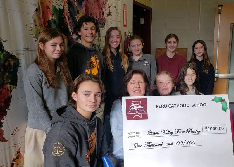 The Peru Catholic Student Council provides a check for $1,000 to Mary Jo Credi, executive director of the Illinois Valley Food Pantry.