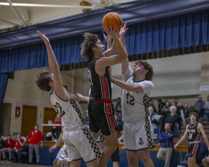 Carson Rowe of Henry-Senachwine gets a shot off against two Marquette defenders during the game on February 7, 2025 at Bader Gym.