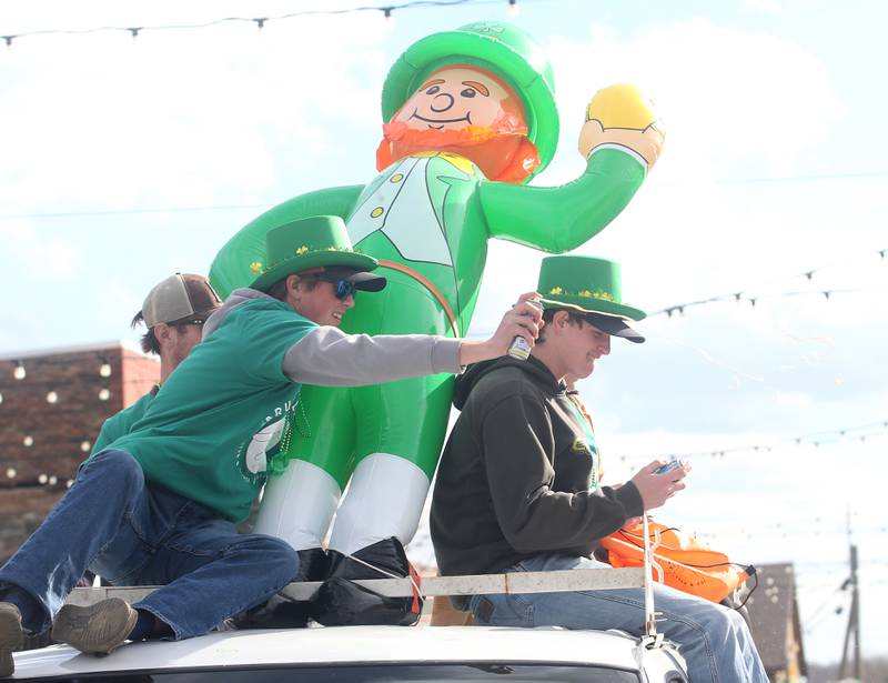 Riley Cetwinski and Michael Milota ride the Bruce and Ollies and Cetwinski Construction float during the St. Patrick's Day parade on Saturday, March 16, 2024 downtown Utica.