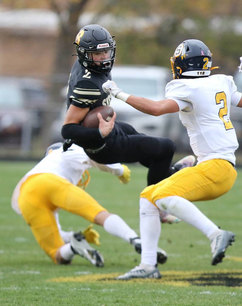 Sycamore's Elijah Meier is brought down by Sterling's Isaiah Mendoza and JP Schilling during their Class 5A state playoff game Saturday, Nov. 12, 2022, at Sycamore High School.