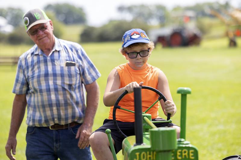 Archer Berg, 8, putts along on Doug Kreiser’s homemade John Deere tractor Saturday, Aug. 3, 2024, at the Living History Antique Equipment Association’s farm show. Kreiser is this year’s featured member and the John Deere is the featured manufacturer.