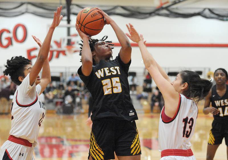 Joliet West's Maziah Shelton (25) takes a shot between Yorkville defenders Alex Stewart (22) and Kaelie Moreno (13) during a girls' basketball game at Yorkville on Thursday, Jan. 19, 2023.