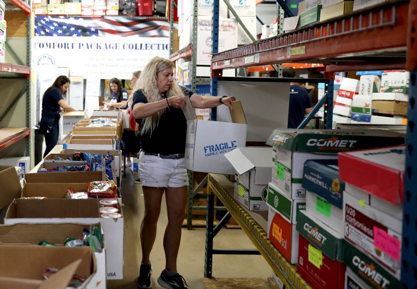 Operation Support Our Troops America Executive Director Linda Tuisl helps pack care packages at their Lisle warehouse.