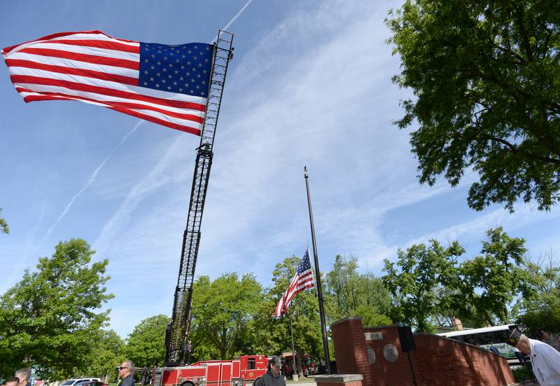 La Grange Park fire fighters post the flag above the Memorial Day ceremony held at Veterans Memorial Park Monday May 26, 2025.