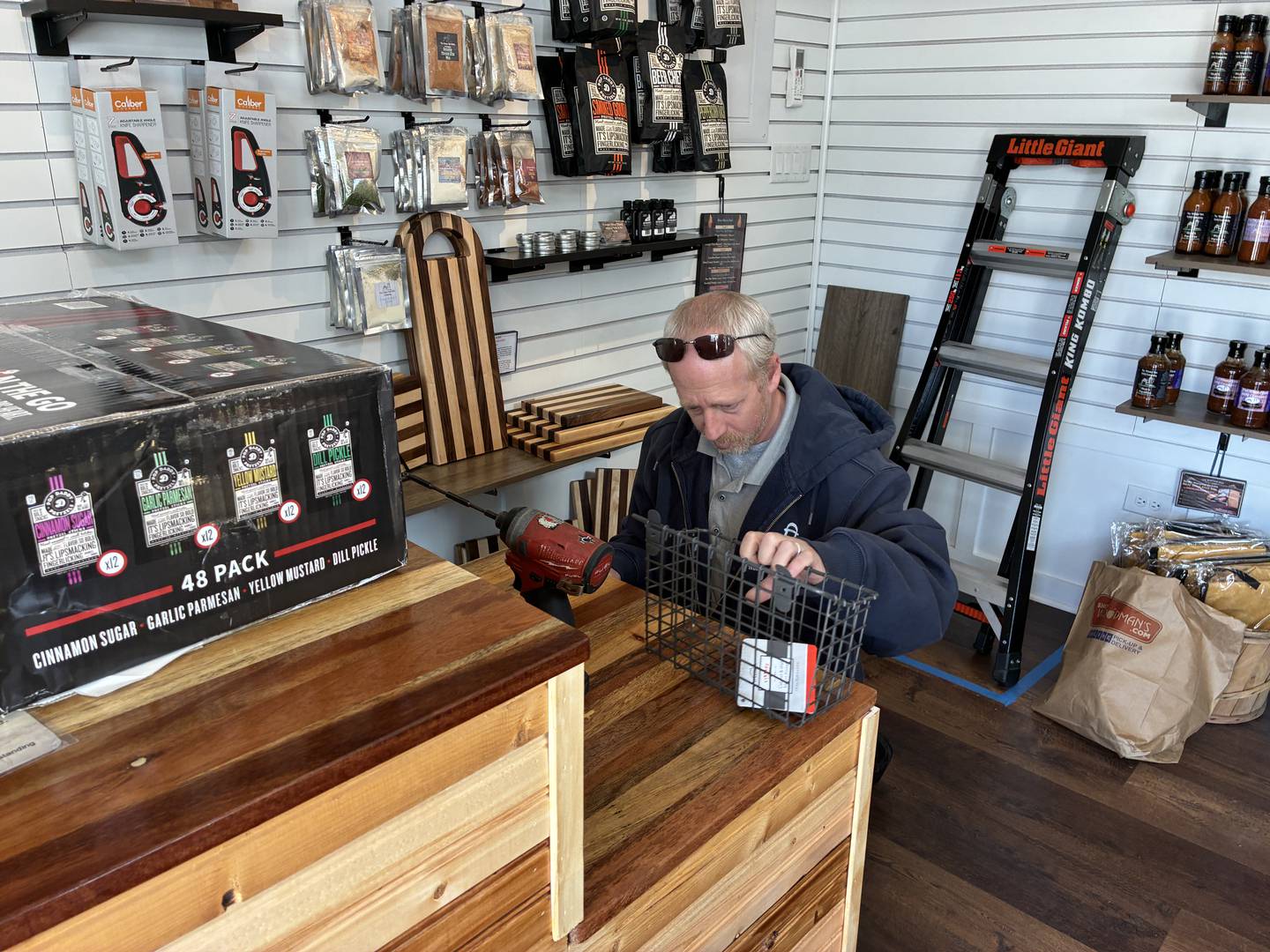 David Winterlang gets ready to drill holes for a shelf at The Winter Inn BBQ Company on Sunday, April 26, 2026, at McHenry's Riverwalk Shoppes. The shops open for the season at 9:30 a.m. Friday, May 1.