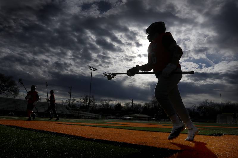 A McHenry lacrosse player controls the ball as team members do passing drills during lacrosse practice Wednesday, March 8, 2023, at McCracken Athletic Field in McHenry.