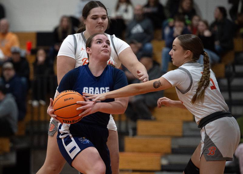 Grace Christian's Lanie St. John, center, looks to take a shot as Beecher's Carmela Irwin, right, and Molly Vladika, back left, guard in a game on Monday, January 5, 2026.