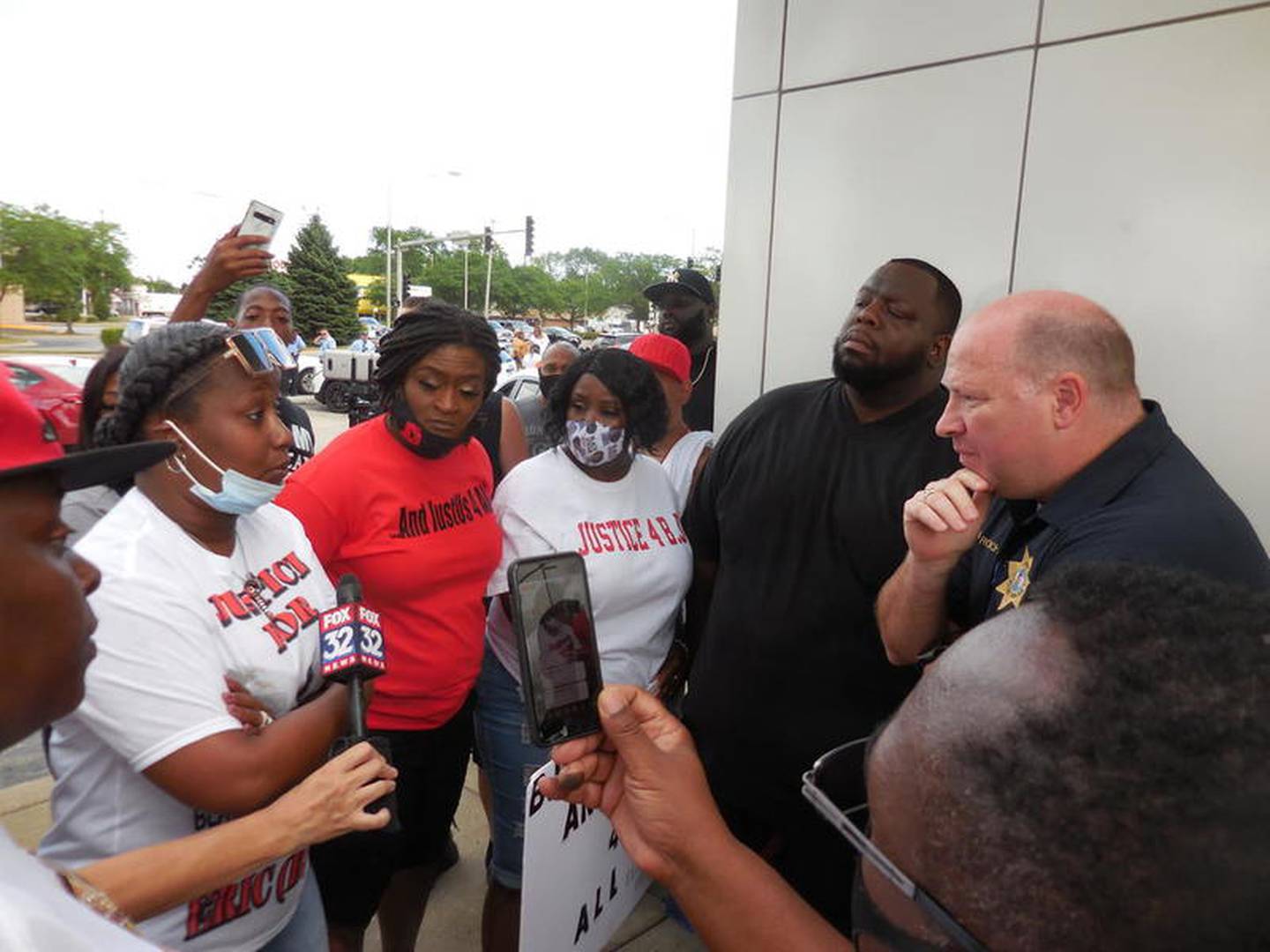 Nicole Lurry, the widow of Eric Lurry, discusses the circumstances of her husband's death with Joliet Police Chief Al Roechner at Sunday's protest.